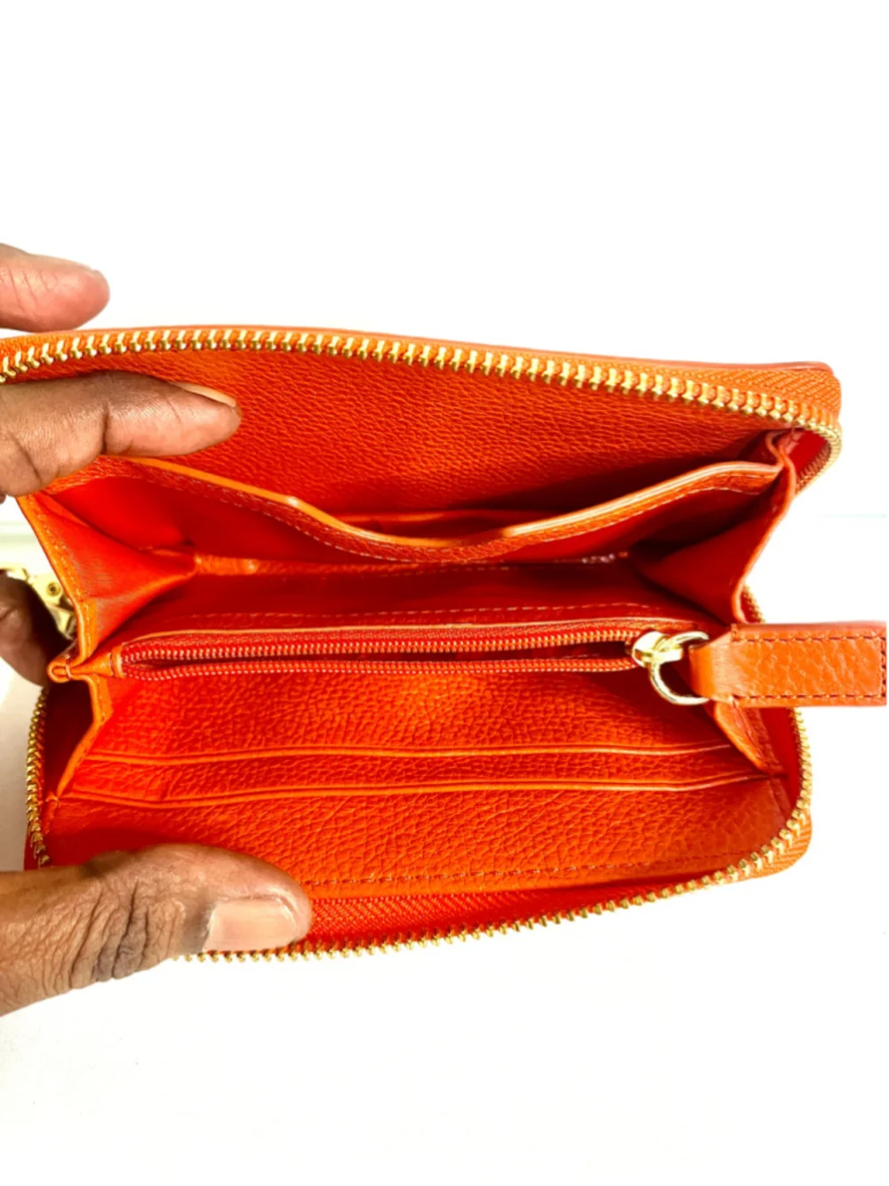 Tory Burch Amanda zip-around wallet featuring vibrant orange pebbled leather.